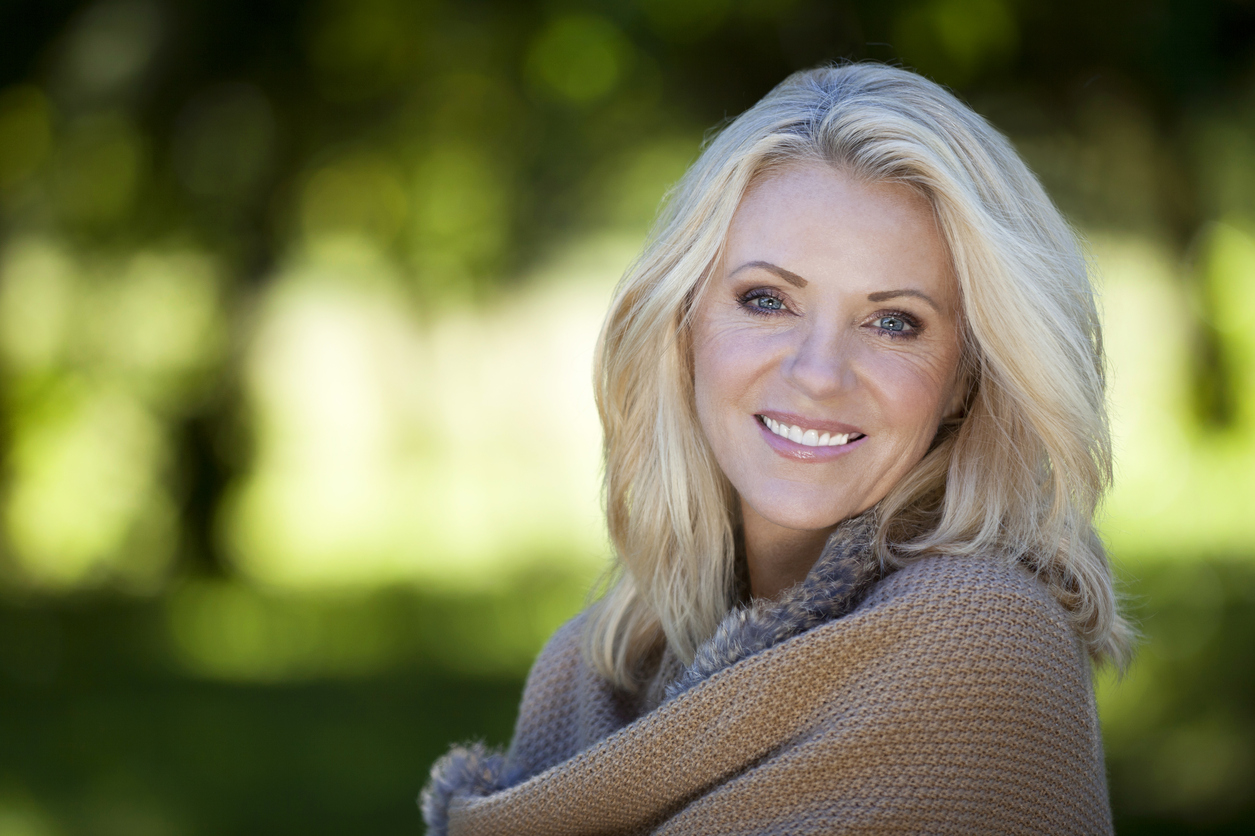 Woman smiling outside with a blanket