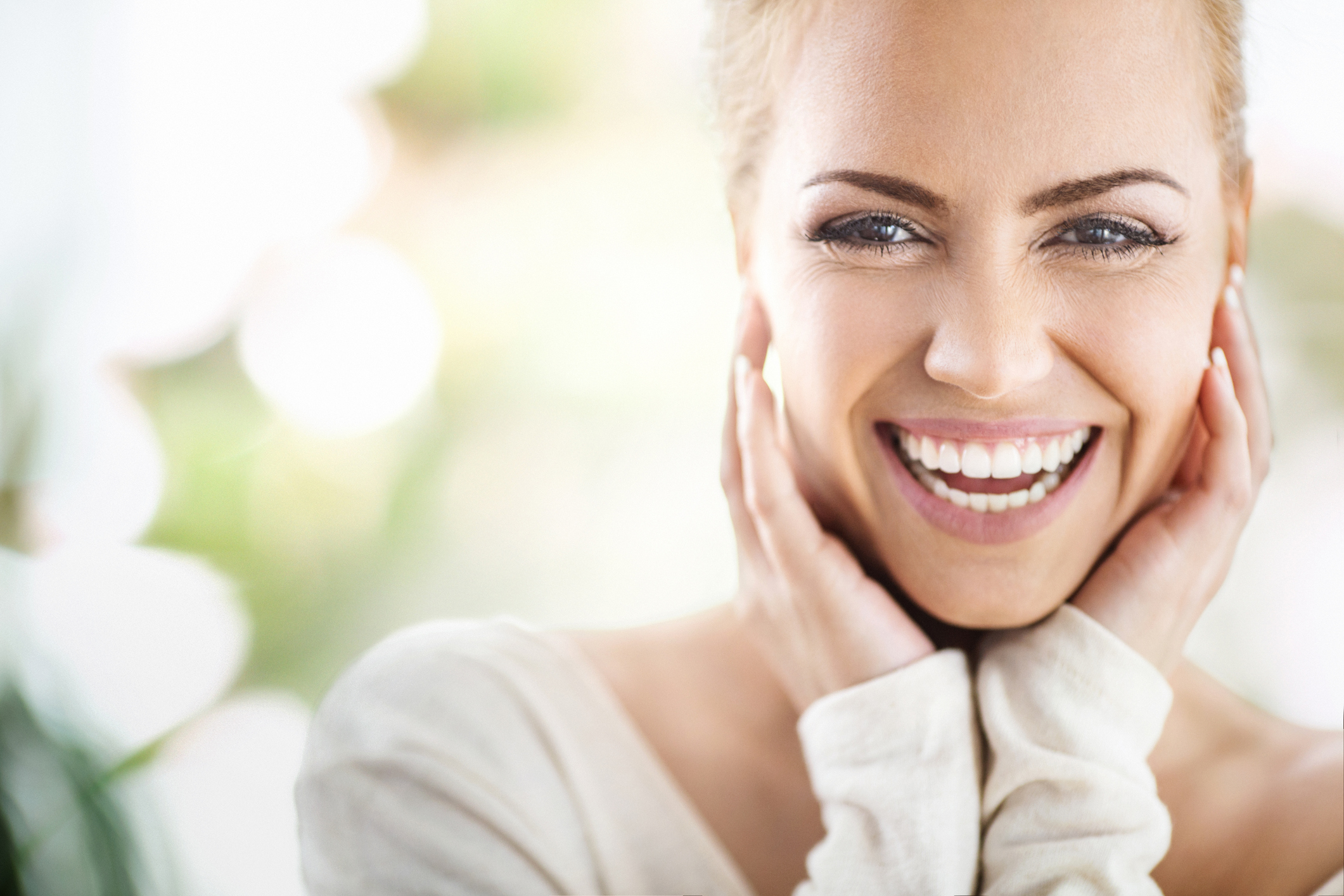 Woman smiling with hands under her chin